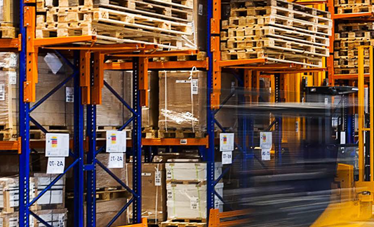 pallets in a warehouse on blue and orange shelves